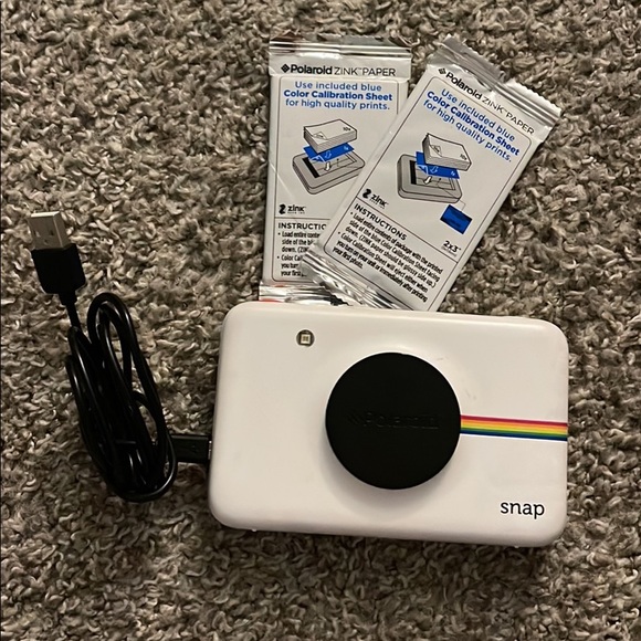 Polaroid Snap camera with charging cord and ZINK paper refills